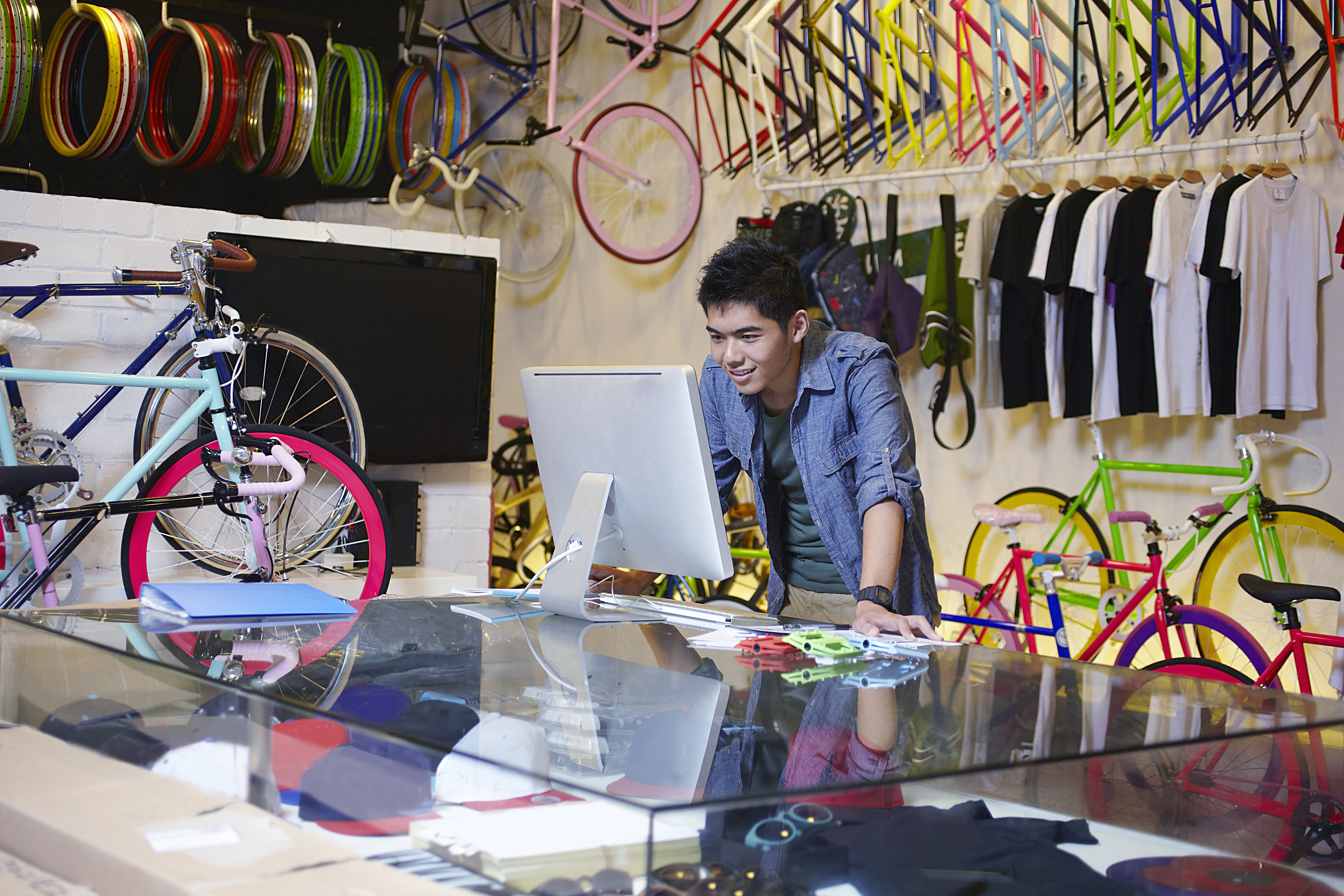 A bike-shop owner working on a laptop between jobs